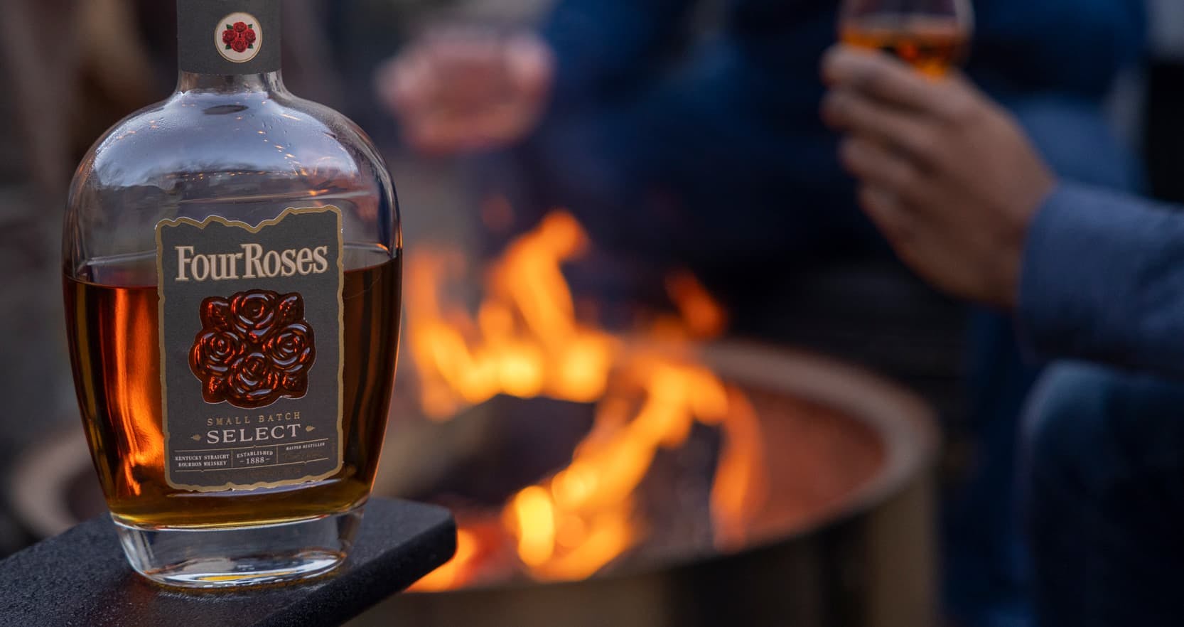 Friends enyoing Four Roses Small Batch Select over a firepit